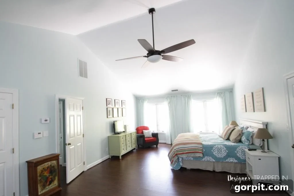 A beautifully transformed master bedroom with serene blue walls and new laminate flooring, demonstrating the power of essential updates.