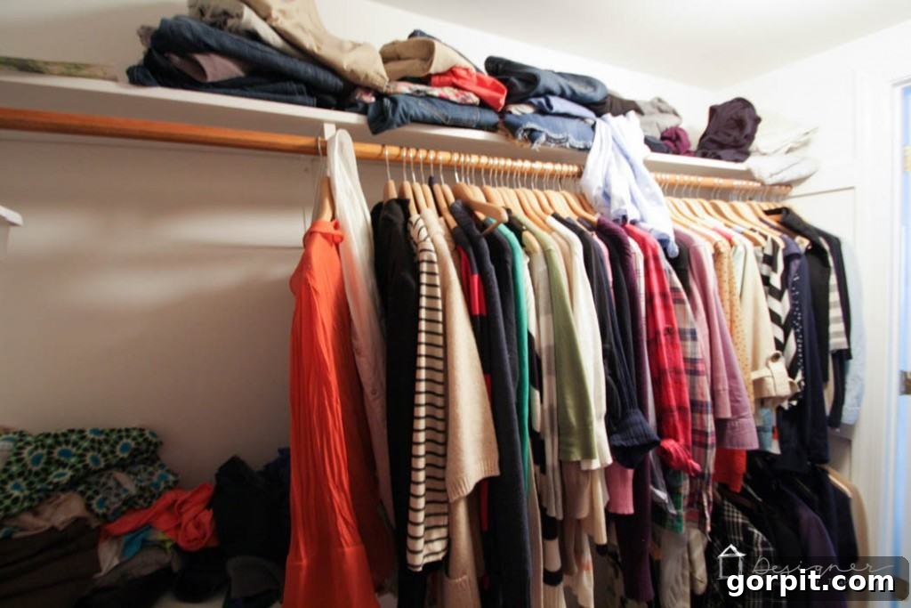 Another view of the disorganized closet, highlighting overflowing shelves and chaotic hanging space. 