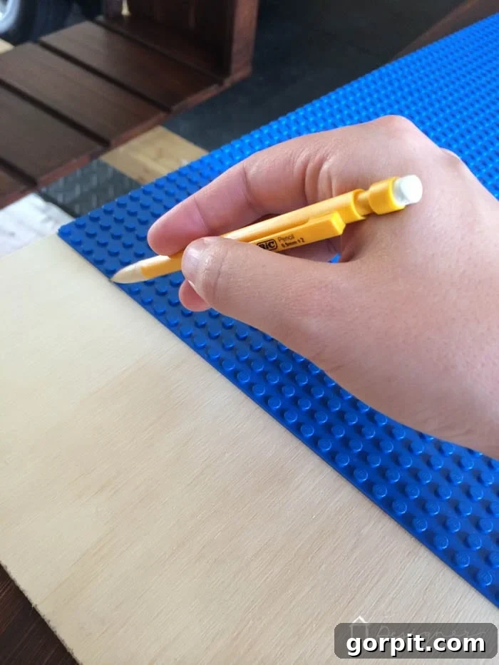 Plywood marked with pencil outlines for Lego base plates, indicating preparation for cutting the tabletop.