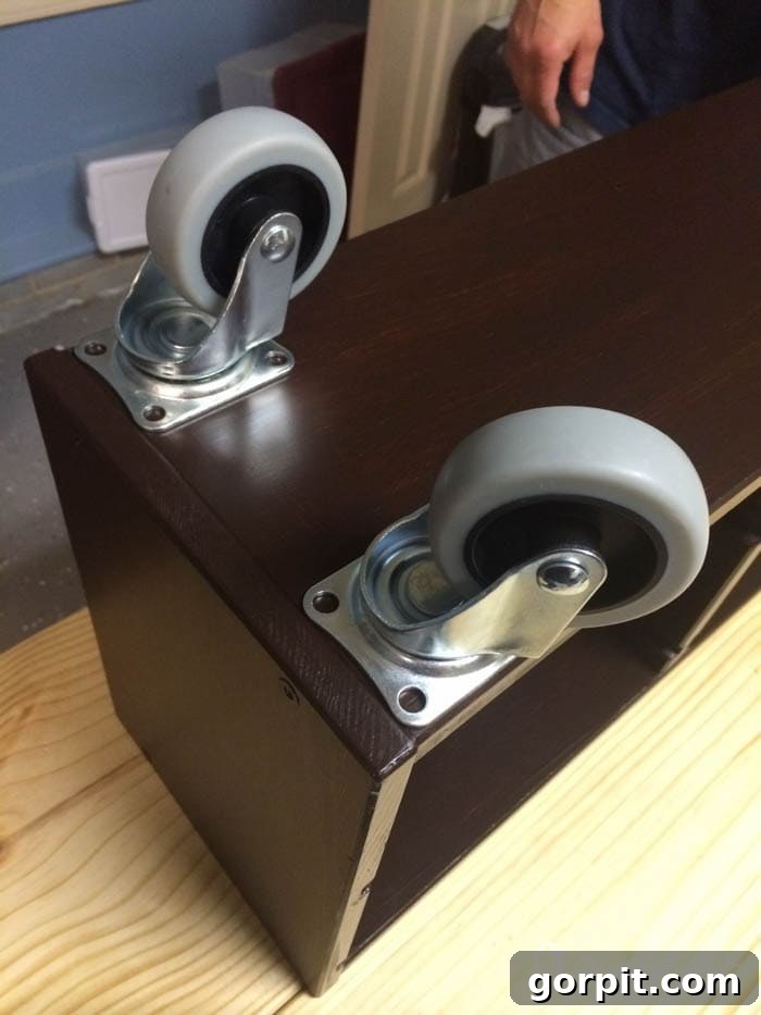 Underside of the Ikea Trofast unit with three-inch casters securely attached to the corners, providing mobility for the Lego table.