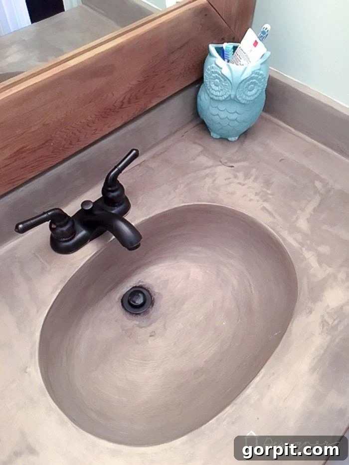 Close-up of DIY concrete sink showing slight discoloration around the drain before the fix.