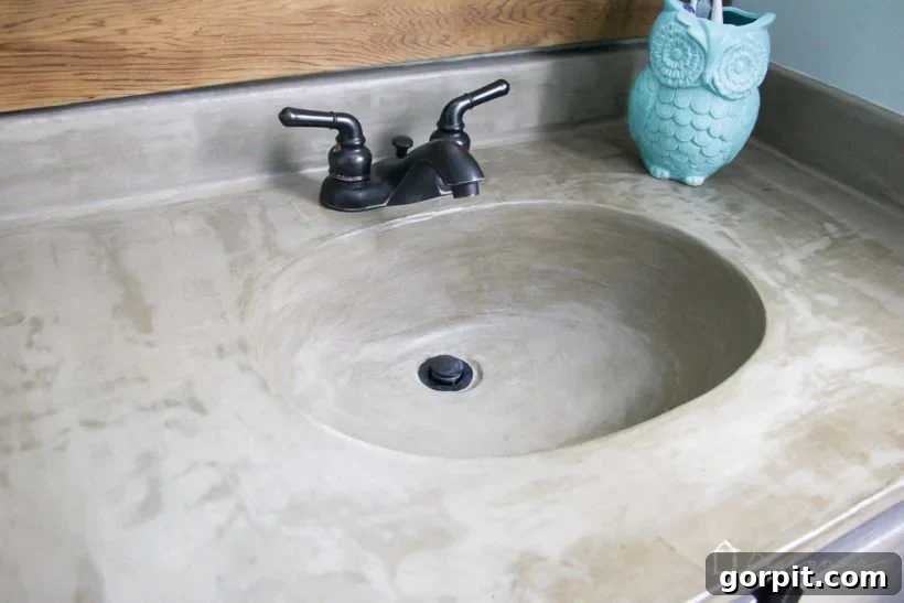 Updated DIY concrete vanity after fixing drain discoloration, showing a clean, uniform surface.
