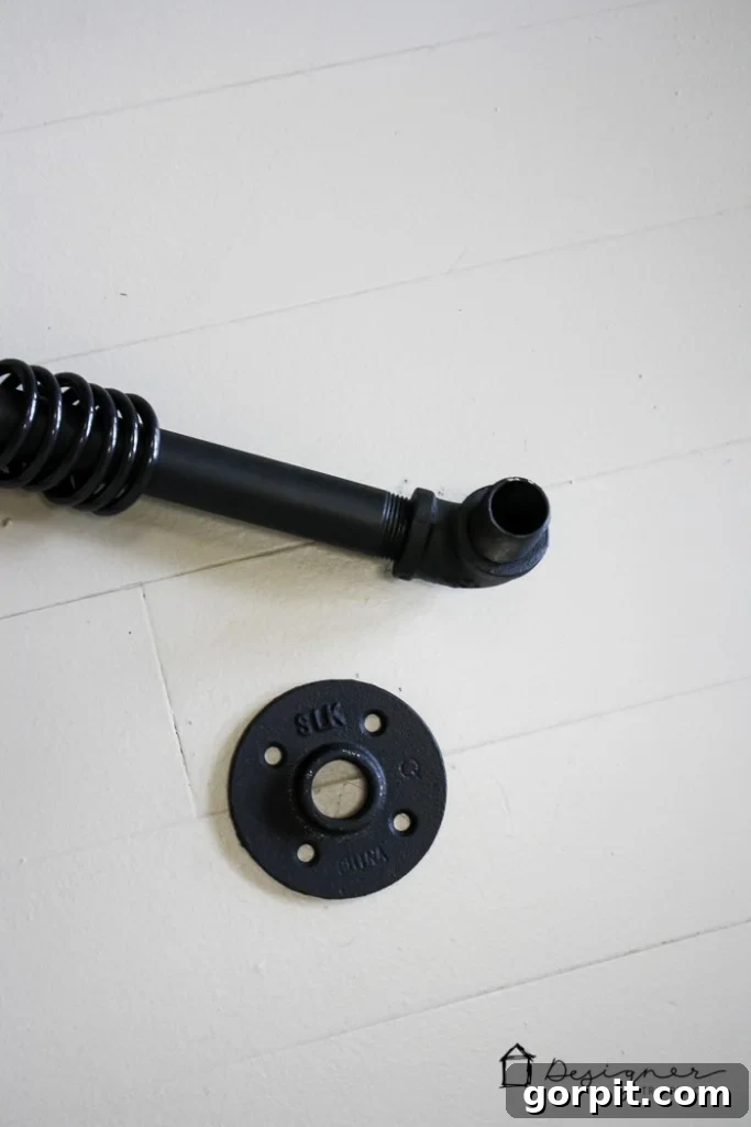 Connecting steel nipples and floor flanges to the elbow joints for the DIY pipe curtain rod.