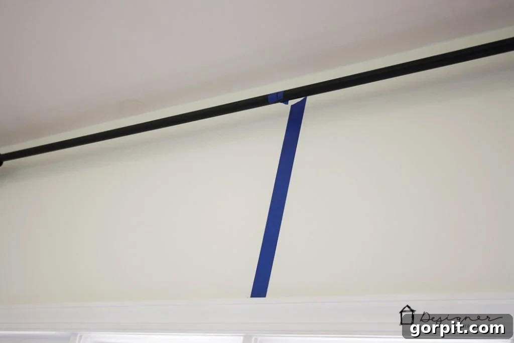 Preparing to hang the DIY industrial pipe curtain rod, showing the assembled rod ready for installation.