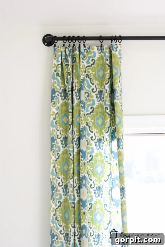 Elegant dining room view with a finished DIY industrial pipe curtain rod and drapes, enhancing the home decor.