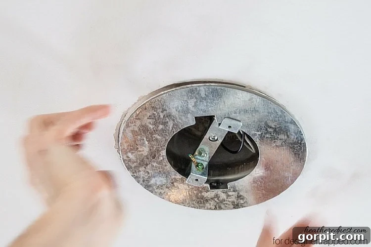Installing the optional ceiling medallion for a polished finish after recessed light conversion.