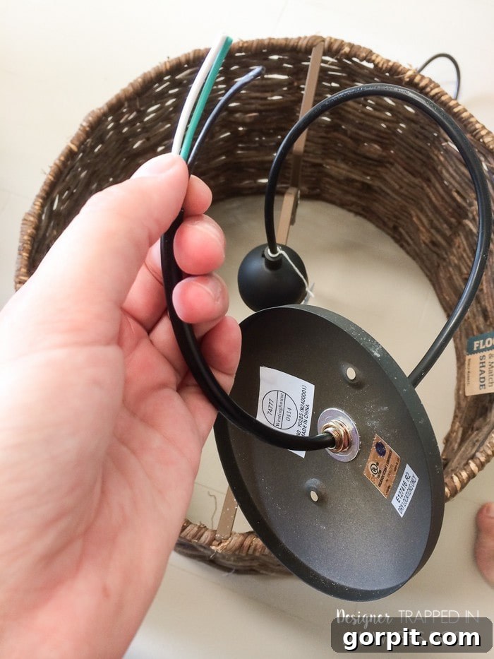 Instant Glow: Beginner-Friendly DIY Lighting 4 Hands feeding the pendant light kit wire through the lampshade to determine the ideal hanging length for the DIY light.