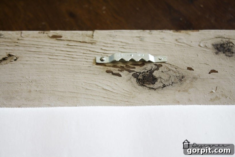 Attaching hanging hardware to the back of a finished DIY picture frame.