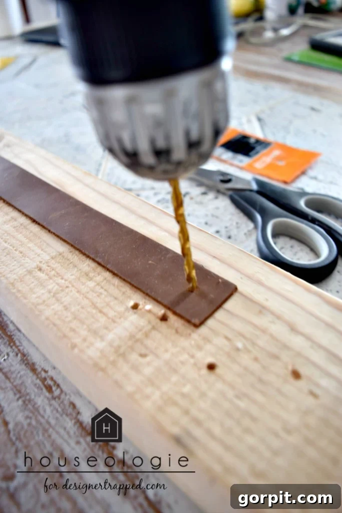 Handcrafting Leather Drawer Pulls for Custom Furniture 4 photo of drill and drill bit being used to drill a hole in a strip of brown leather