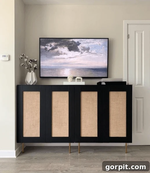 A console table hack from IKEA kitchen cabinets holds storage and a TV on top. 