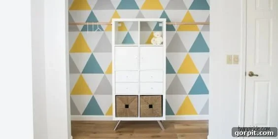 A graphic wall with triangle patterns has a IKEA Kallax unit in front to provide additional storage. 
