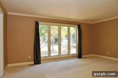 Before image of a dull, beige formal living room, soon to be a vibrant kids' playroom