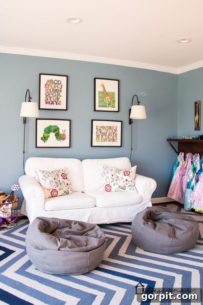 The playroom's dedicated desk area with DIY pipe shelving, organized with books and supplies, an ideal example of practical kids' playroom ideas.