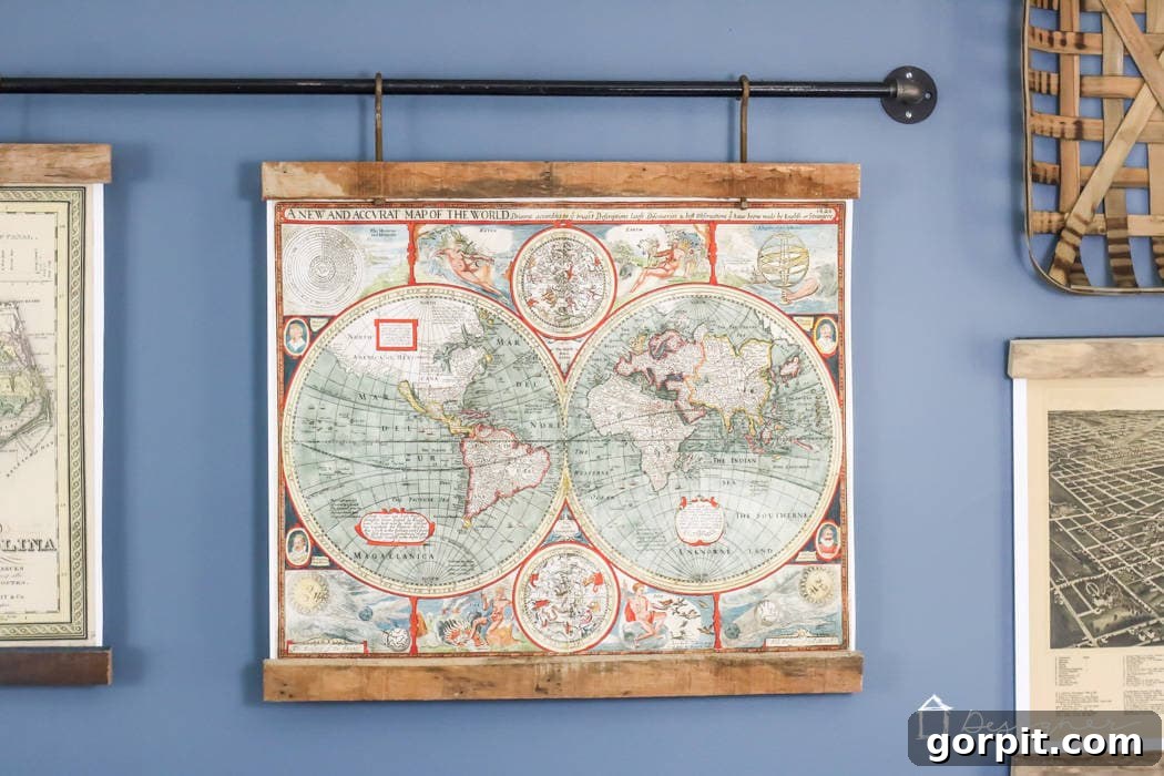 Three large maps framed in reclaimed wood, hanging elegantly from an industrial pipe, creating a stunning focal point in a modern rustic living room.