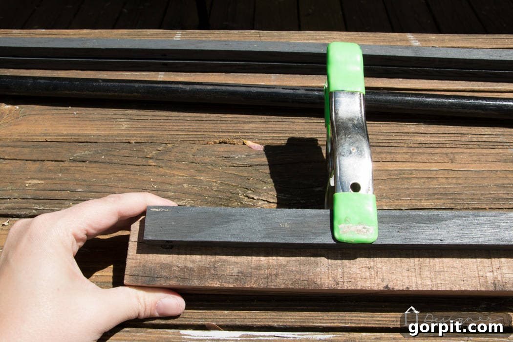 Stacked reclaimed wood pieces firmly held by multiple clamps while the wood adhesive cures, emphasizing the importance of consistent pressure for a strong bond.