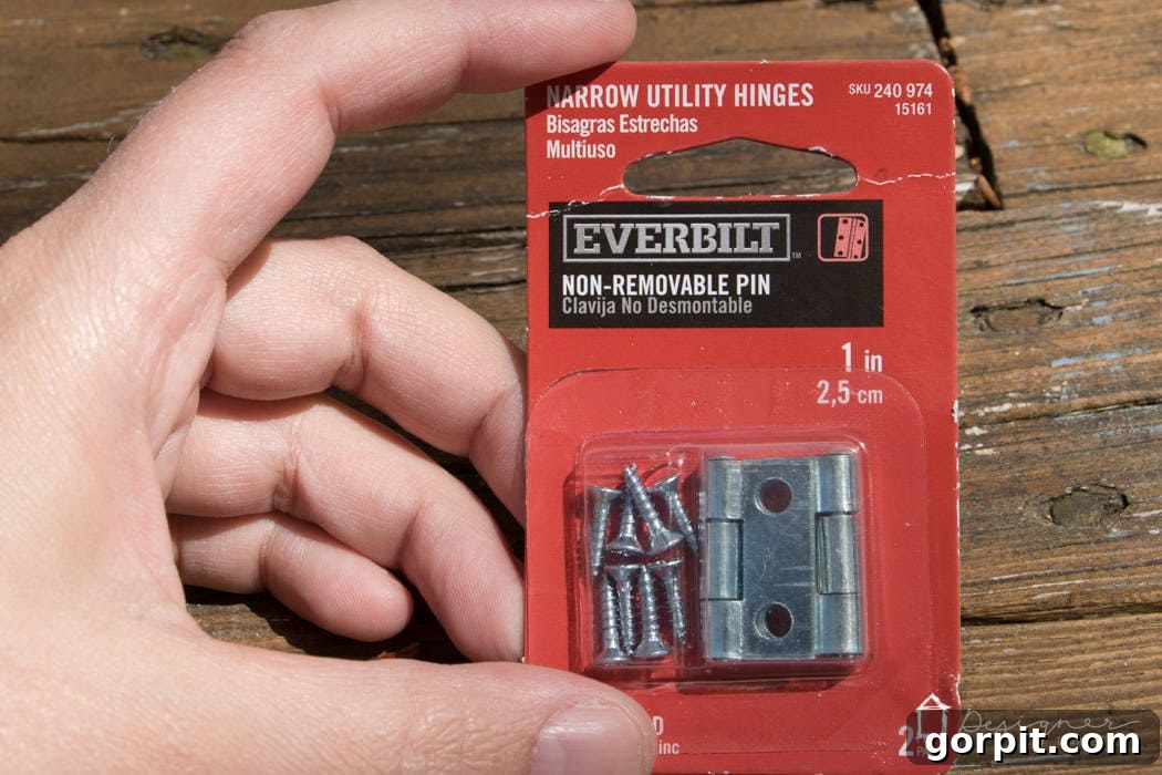 Hinges being meticulously attached to the backer strips of a DIY picture frame, demonstrating the precise installation of the mechanism for easy print insertion and removal.