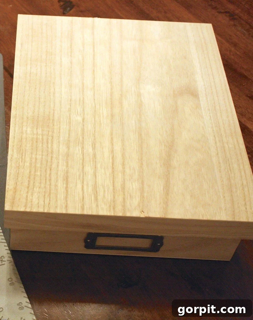 Applying wood stain to an unfinished wooden box for a DIY desk organizer tray