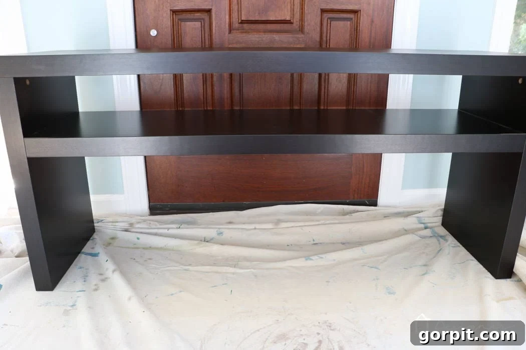IKEA Lack Transformation: Designer Style for Less 3 A plain black IKEA Lack sofa table resting on a painter's drop cloth, ready for its dramatic transformation.