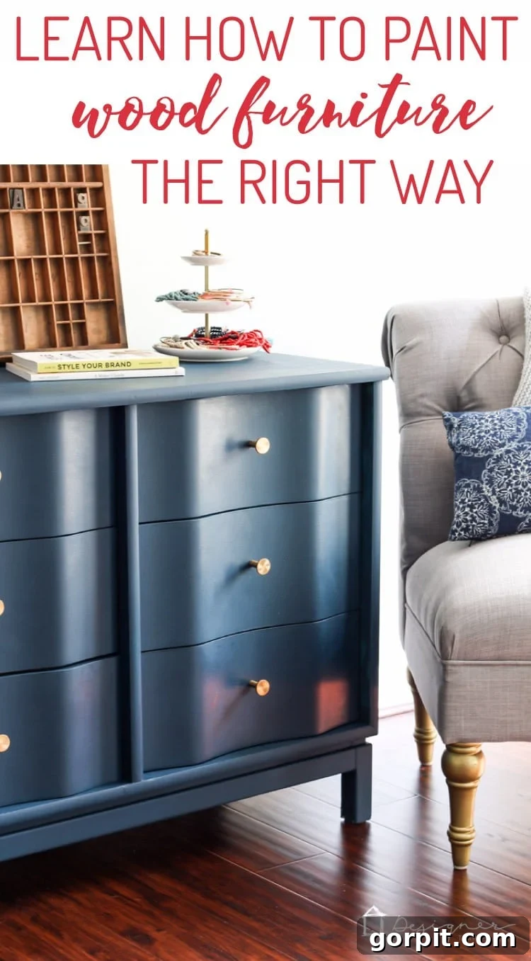 Wood Wonders: Your Guide to Transforming Furniture with Paint 15 A long graphic of a blue painted dresser with a wavy front, gold hardware, and a grey tufted chair nearby. "DesignerTrapped.com" is in the lower right-hand corner, and the text above reads, "Learn How to Paint Wood Furniture the Right Way."