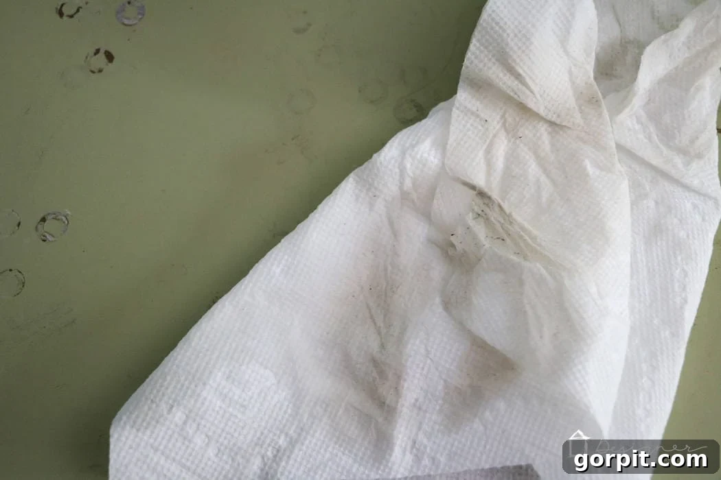Wood Wonders: Your Guide to Transforming Furniture with Paint 4 Residue and dirt on a paper towel on a dull green surface is visible confirmation that Simple Green cleaner works and is a crucial step on how to paint wood furniture.