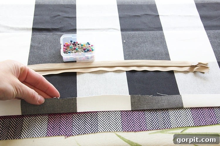 Sew Your Own Zippered Pillow Cover 5 A close-up shot of fabric being pressed with an iron, creating a clean crease along the edge in preparation for zipper attachment.