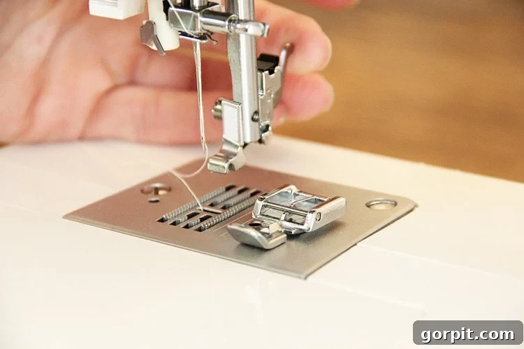 Sew Your Own Zippered Pillow Cover 8 A sewing machine's zipper foot is being attached, showcasing the mechanism that secures it in place for precise stitching.