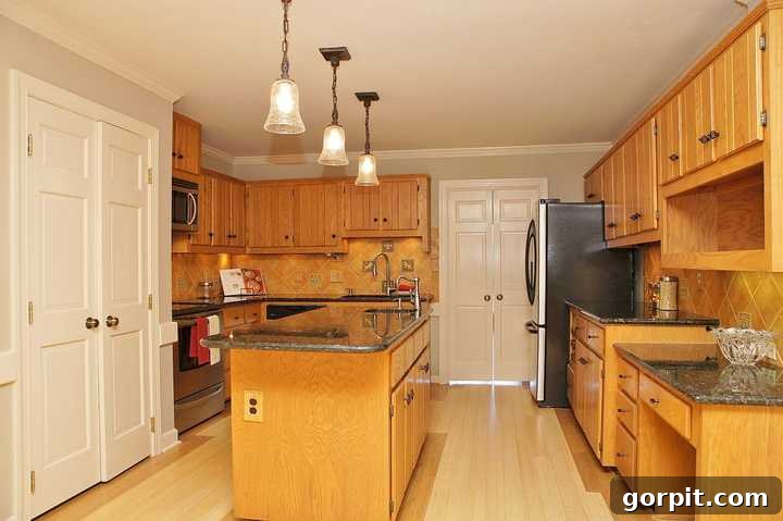 A before picture of a plain, old wooden kitchen with an island and outdated cabinets. 