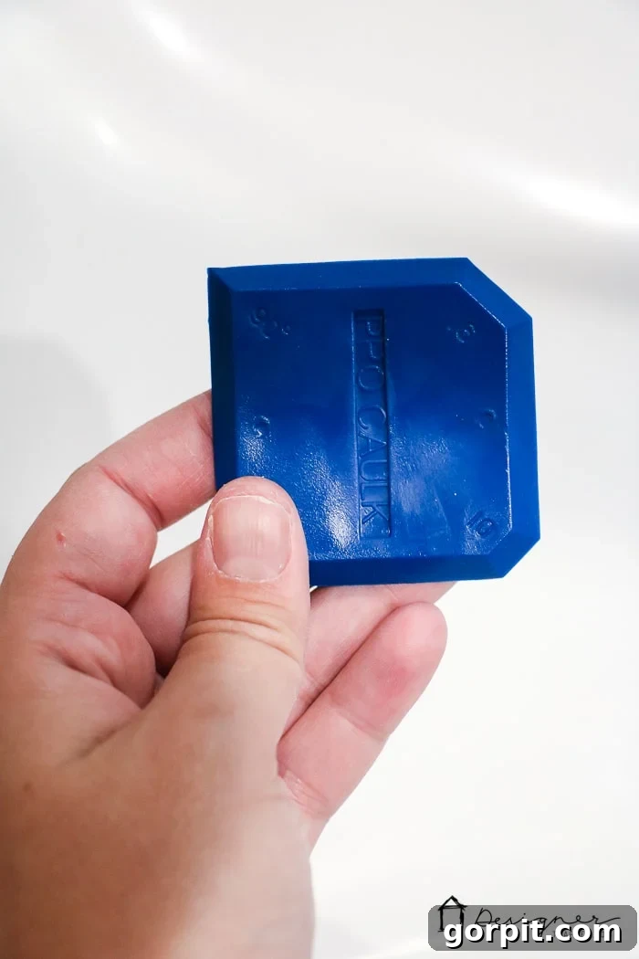 Use a caulk smoothing tool to create a perfectly clean and concave caulk bead around your bathtub. This step is essential for a professional and durable finish.