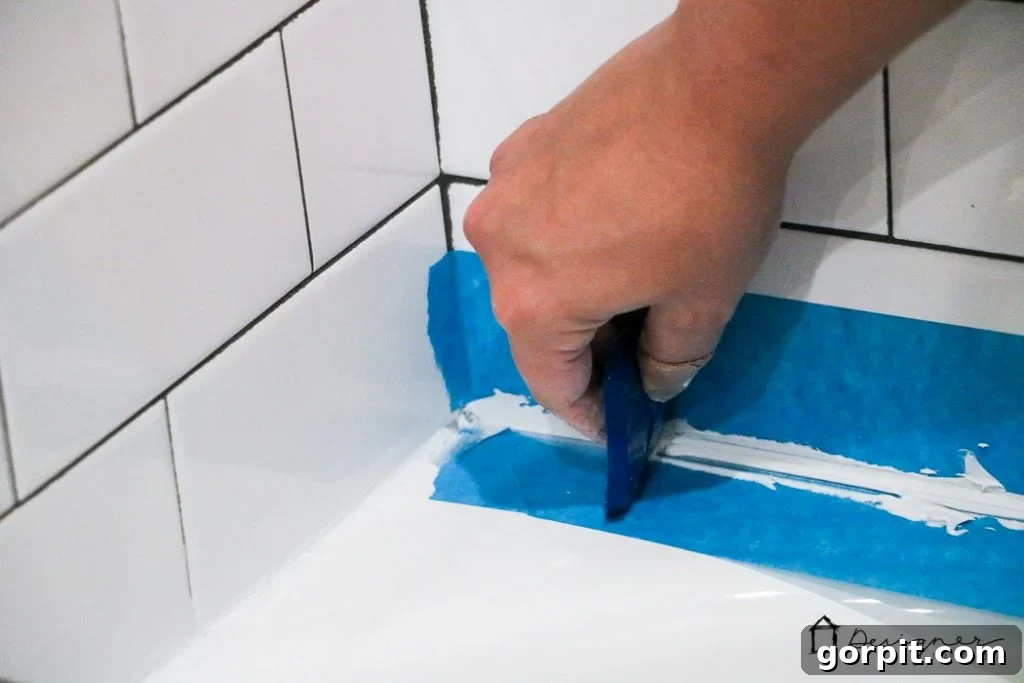 Achieve a flawless, professional caulk line by carefully smoothing the applied caulk with a specialized tool. This ensures a watertight seal and a beautiful finish.
