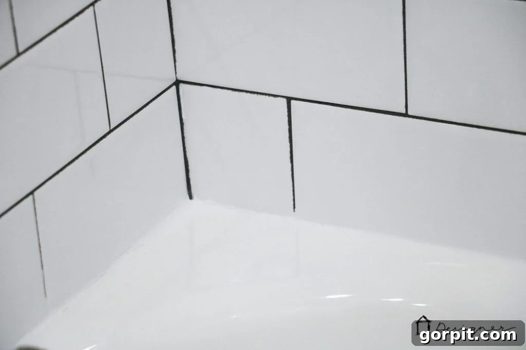 Carefully remove painter's tape immediately after smoothing caulk to reveal a perfectly straight and clean caulk line around your bathtub.