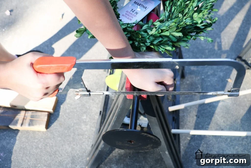 Adjusting the height of the boxwood wreath stand with a hacksaw