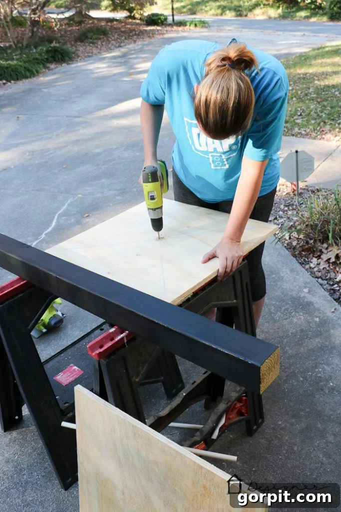 Marking the plywood center, drilling pilot holes, and painting all components black