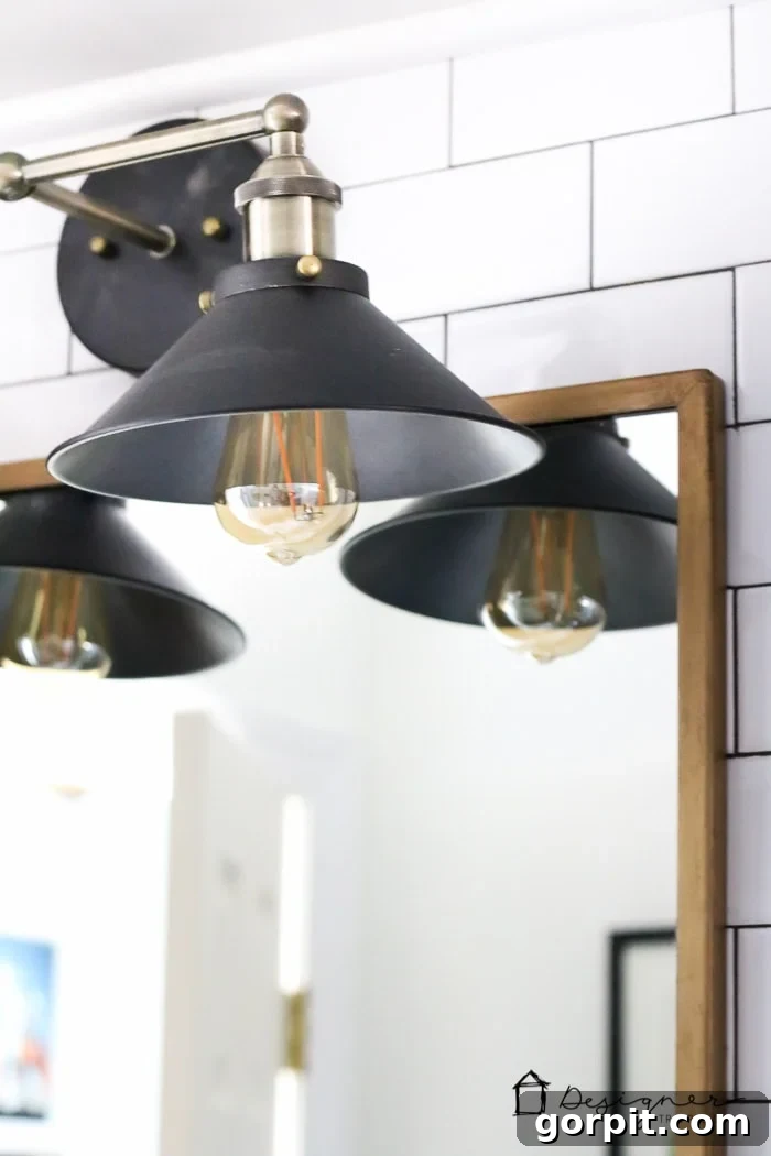 Elegant and budget-friendly vanity lights illuminating a beautifully renovated bathroom.
