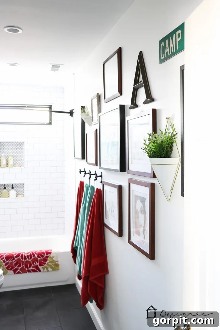 Close-up of a geometric wall vase with an air plant, part of a cheerful bathroom gallery wall.