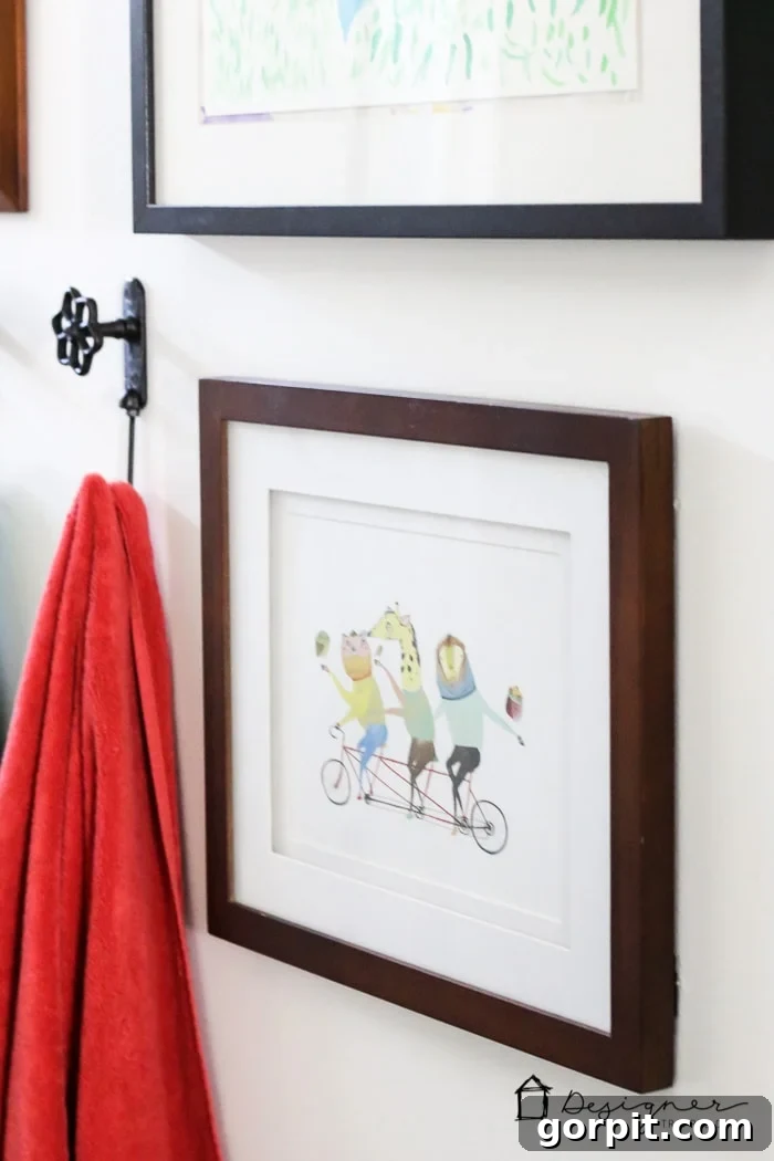 Artistic display with framed prints and wall decor in a modern, family-friendly bathroom.