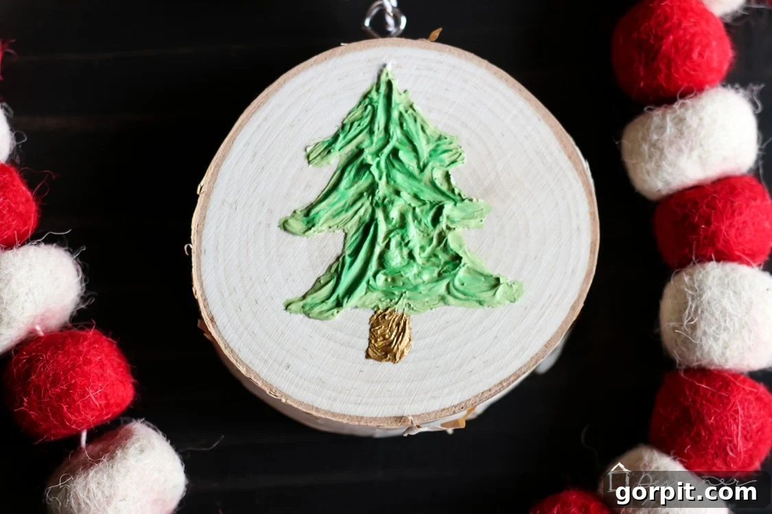 The fully completed caulk-textured Christmas tree ornament, showcasing its rustic beauty and unique tactile surface.