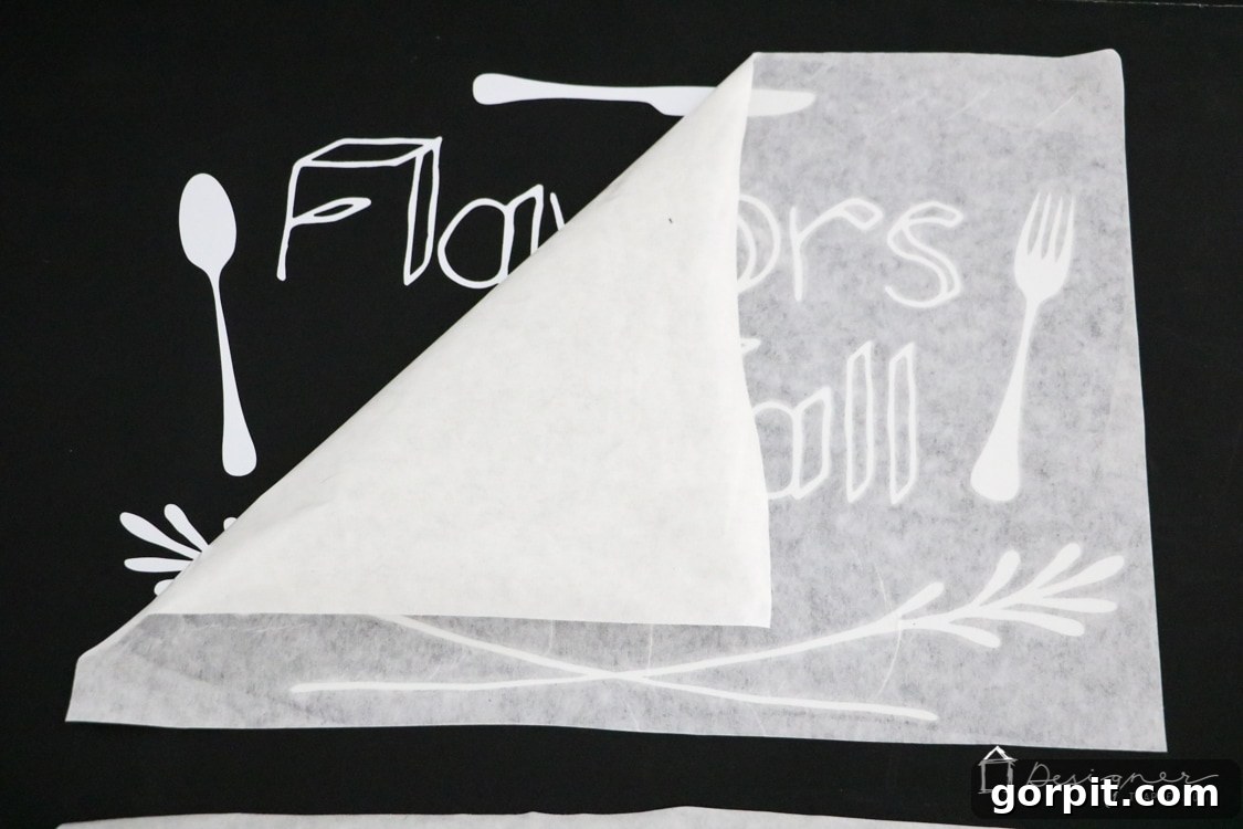 Applying vinyl design to a project using transfer tape for precision