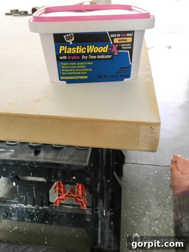 Effortless Pipe Desk DIY 4 Sanding the smooth, filled edges of a hollow core door, demonstrating the transformation from rough to ready for paint in a DIY desk project.