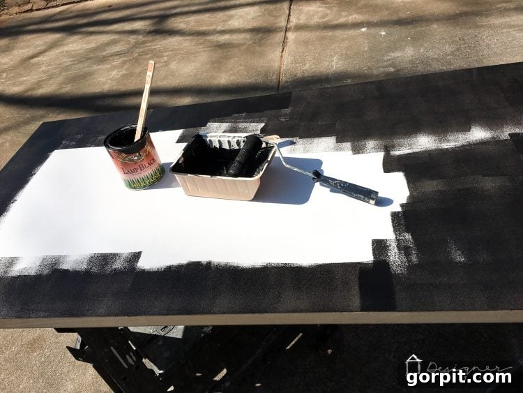 Effortless Pipe Desk DIY 5 Painting a hollow core door black for an industrial pipe desk, showing the surface being transformed with a smooth, even coat of paint.