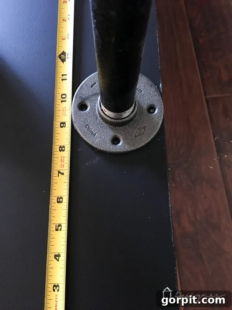 Effortless Pipe Desk DIY 6 Applying DAP Rapid Fuse adhesive to the bottom of a metal floor flange before attaching it to the underside of a hollow core door for a DIY desk.
