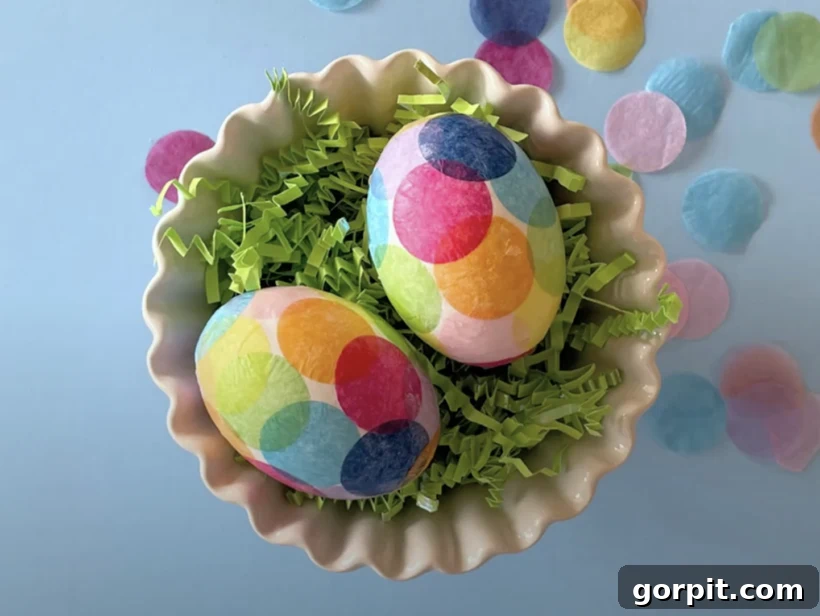 Vibrantly colored Easter eggs decorated with delicate tissue paper, showcasing a unique and artistic approach to egg design.