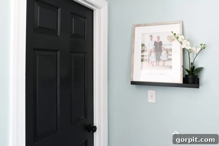 After: Modern black interior door with sleek Schlage Aged Bronze hardware.