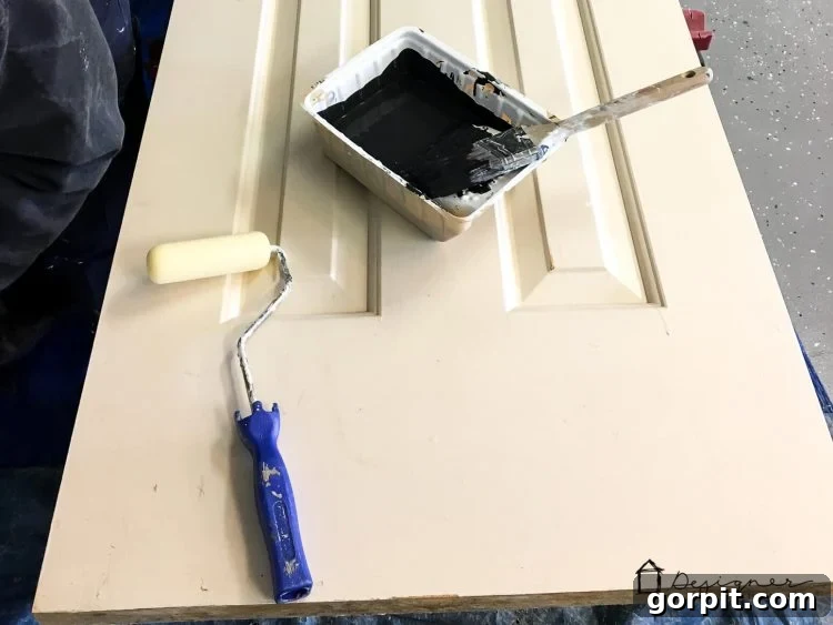 Painting an interior door black using a foam roller and bristle brush for a smooth finish.