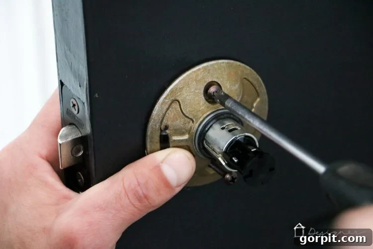 Tightening the inner plate of a Schlage door knob during installation.