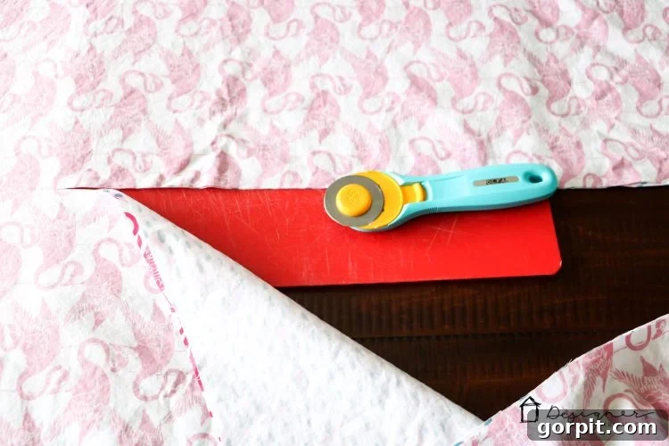 Flat Sheet Bed Canopy: Your Cozy Oasis 4 Using a rotary cutter to precisely cut through two layers of flat sheets, preparing them for the bed canopy project.