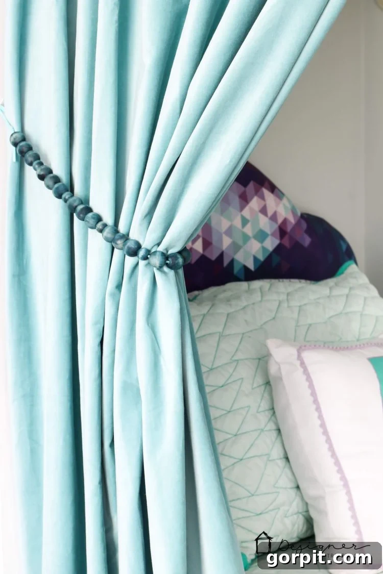 An artistic wide shot of the bed nook showcasing the DIY curtain tie backs and the overall cozy decor.