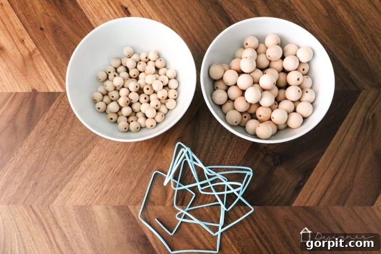 All the materials laid out for making DIY wood bead curtain tie backs, including beads, stain, cord, and tools.