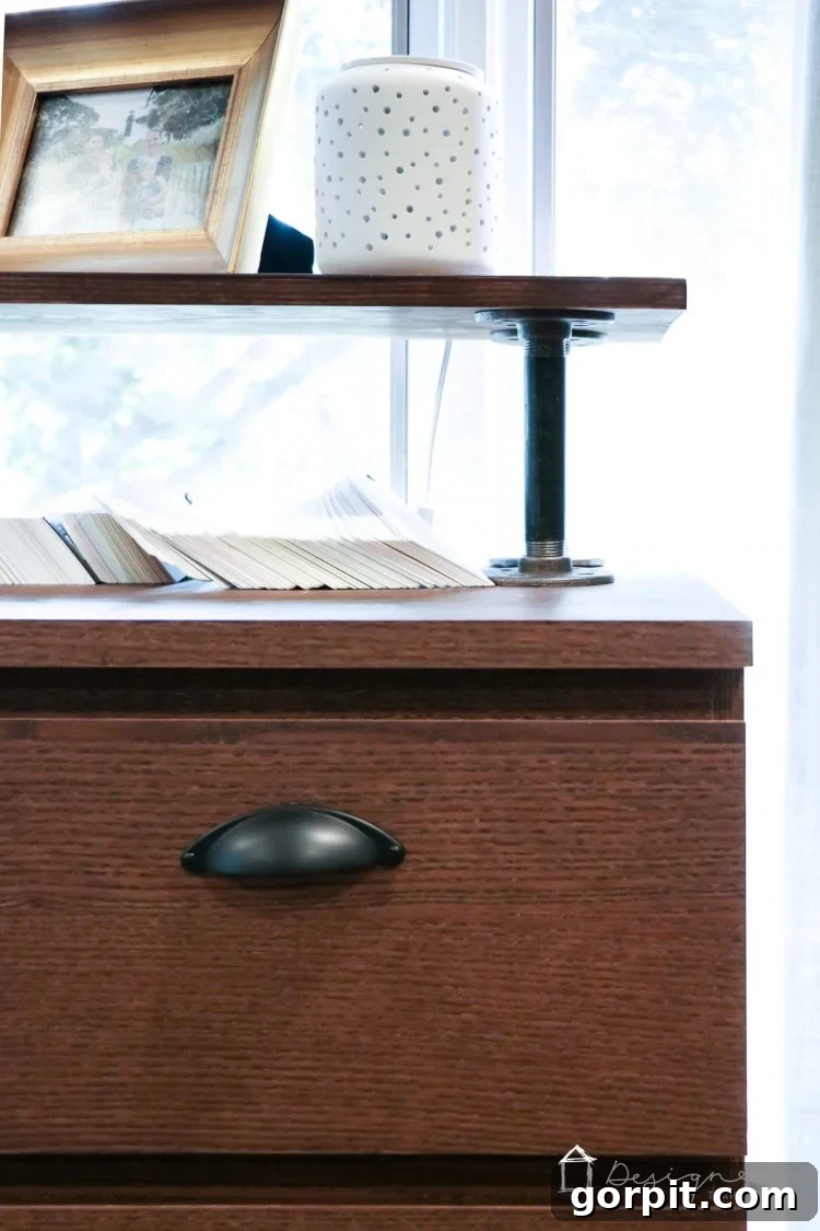 Detail shot of the industrial pipes and flanges supporting the wooden top, showcasing the robust industrial aesthetic of the Malm hack.
