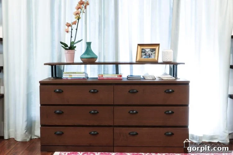 The finished Ikea Malm industrial dresser hack, showcasing a dark wood finish with metal pipe legs and sleek drawer pulls, looking high-end on a budget.