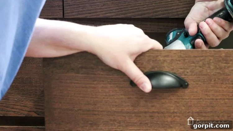 New drawer pulls are securely attached to the Ikea Malm drawer front, showing the finished hardware installation.